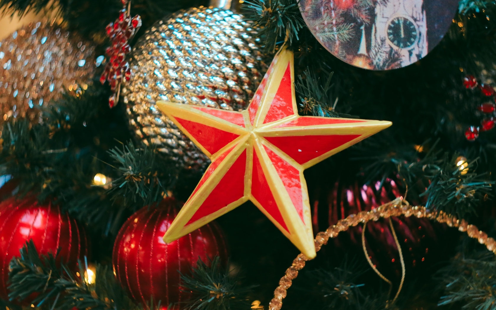 Большая красная звезда на елке с игрушками