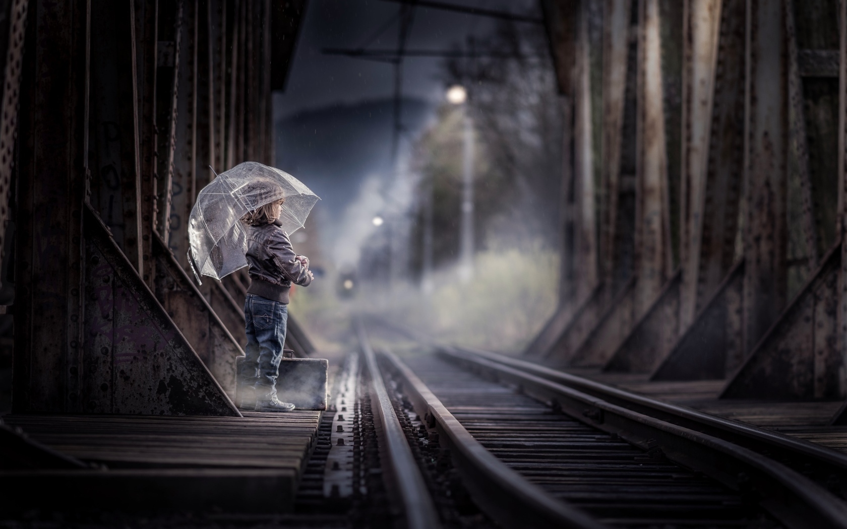 Ребенок под зонтом у железной дороги