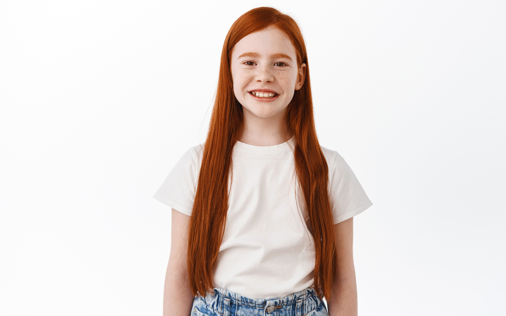 Улыбающаяся рыжеволосая девочка на белом фоне
