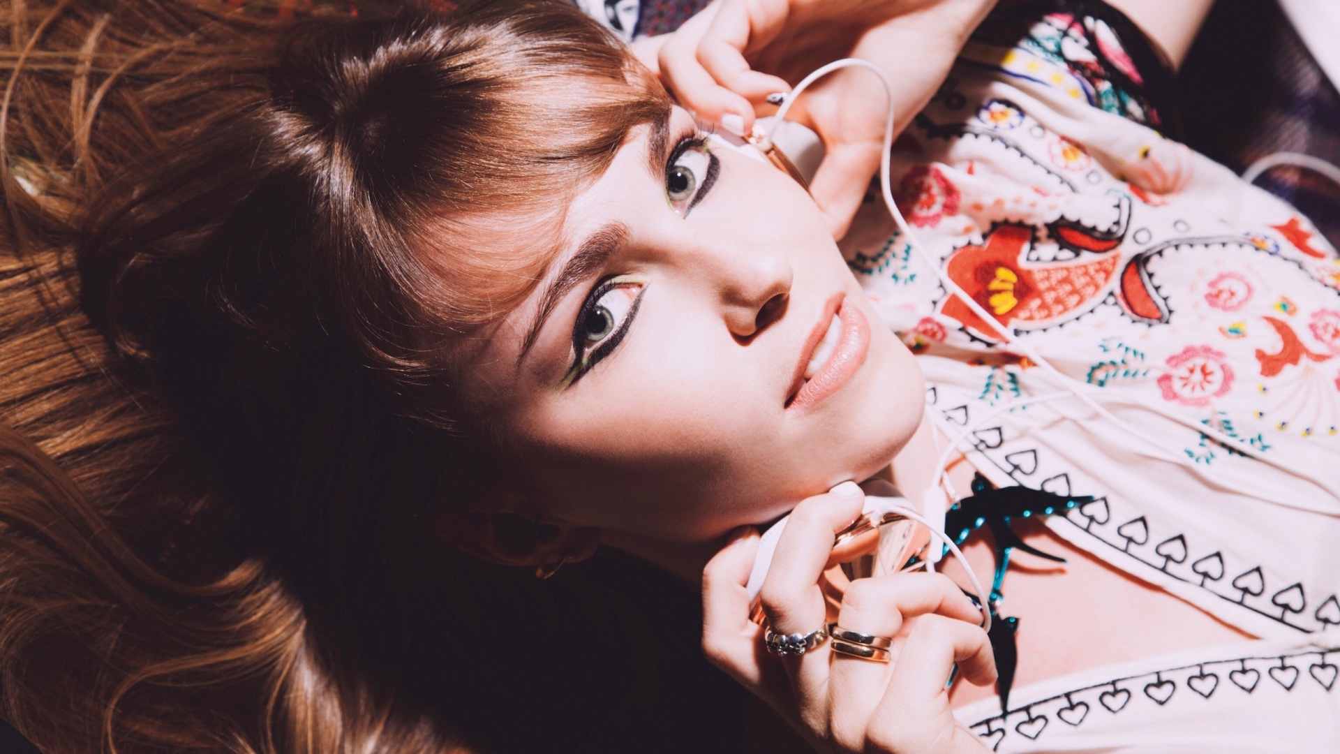 Девушка лежит с наушниками