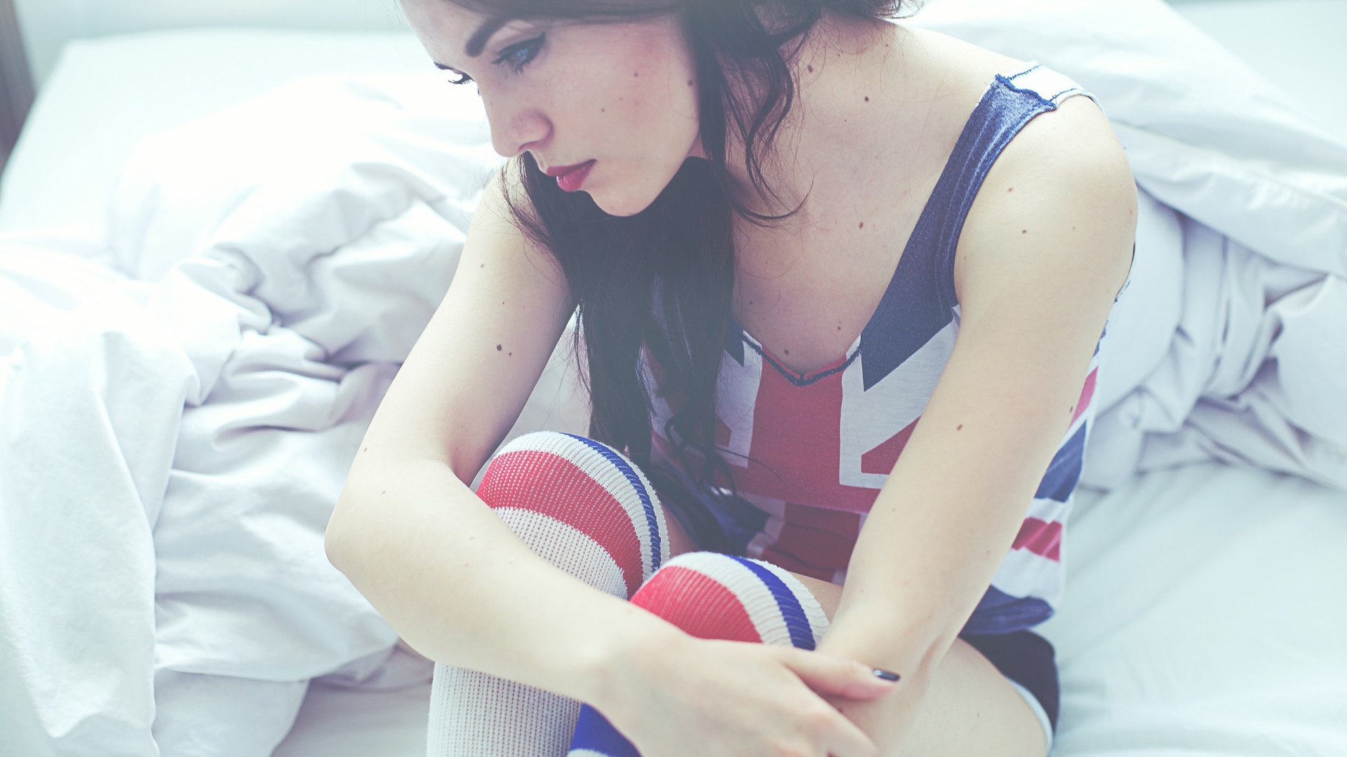 Девушка грустит на кровати