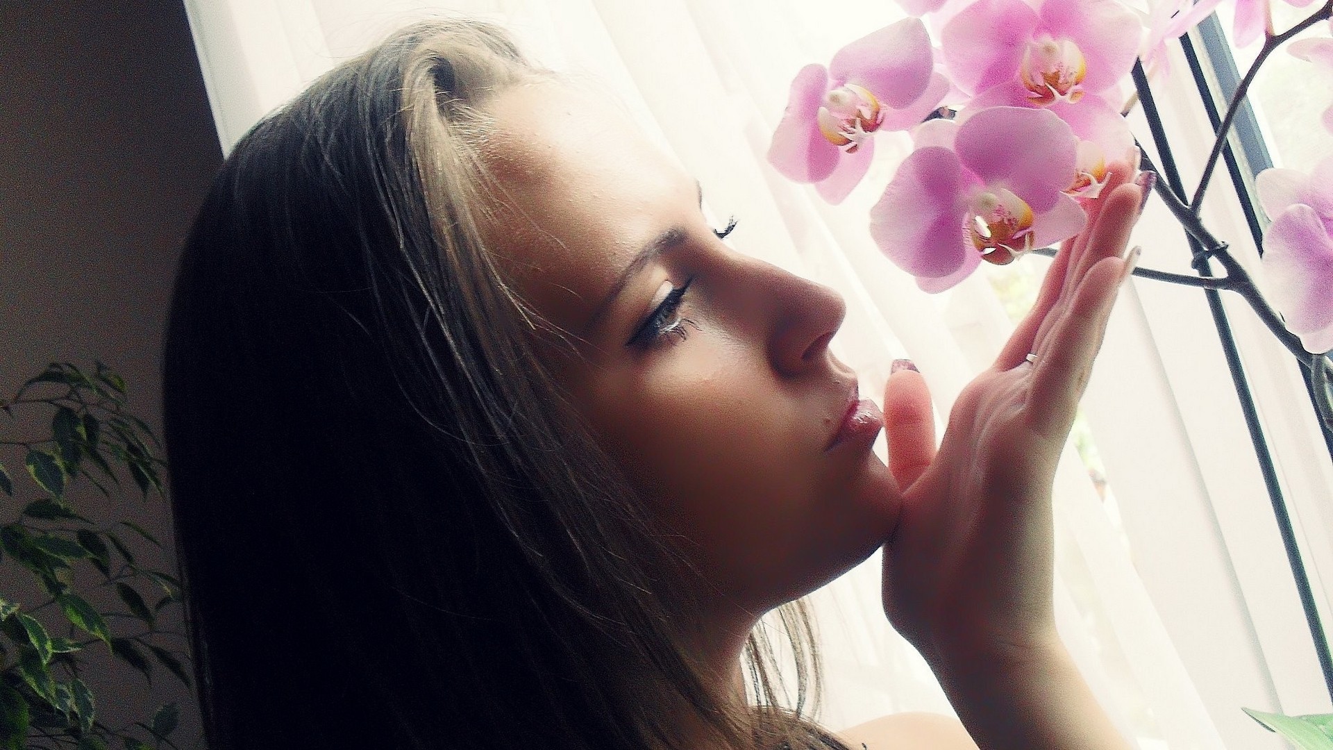 Девушка смотрит орхидею