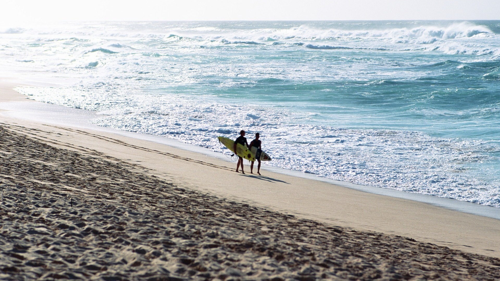 Два человека идут по пляжу