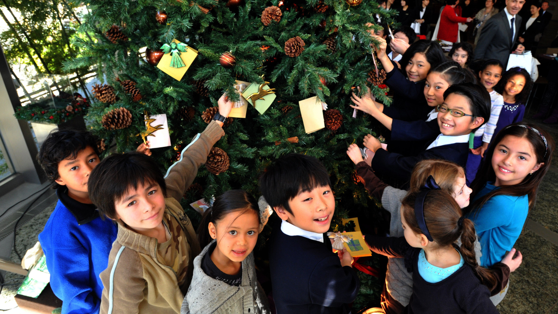 Дети рядом с новогодней елкой
