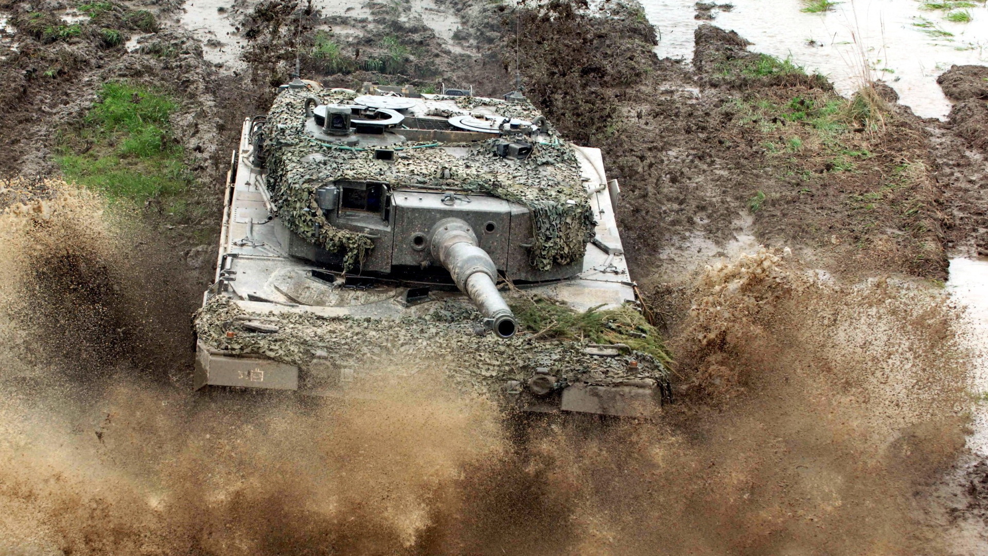 Танк в маскировке едет по грязи