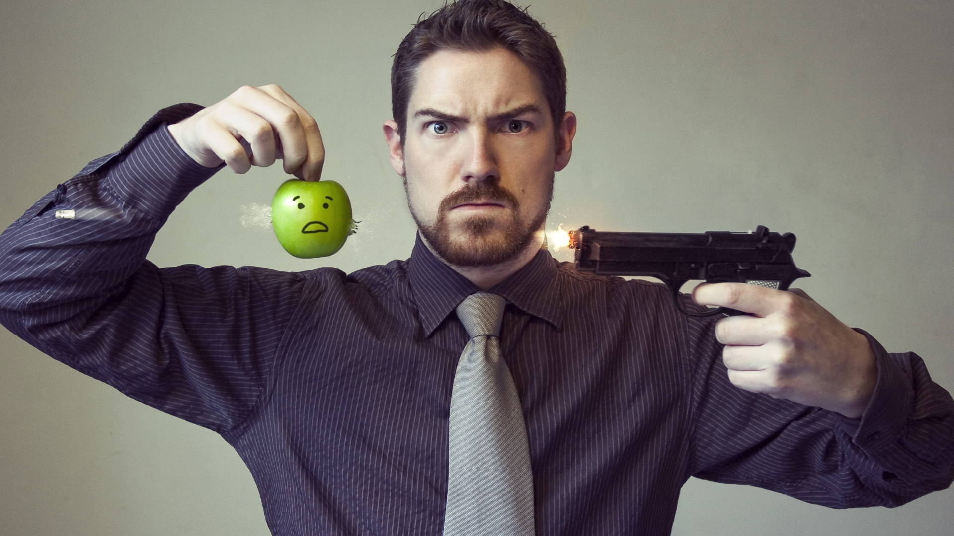 Мужчина стреляет в яблоко