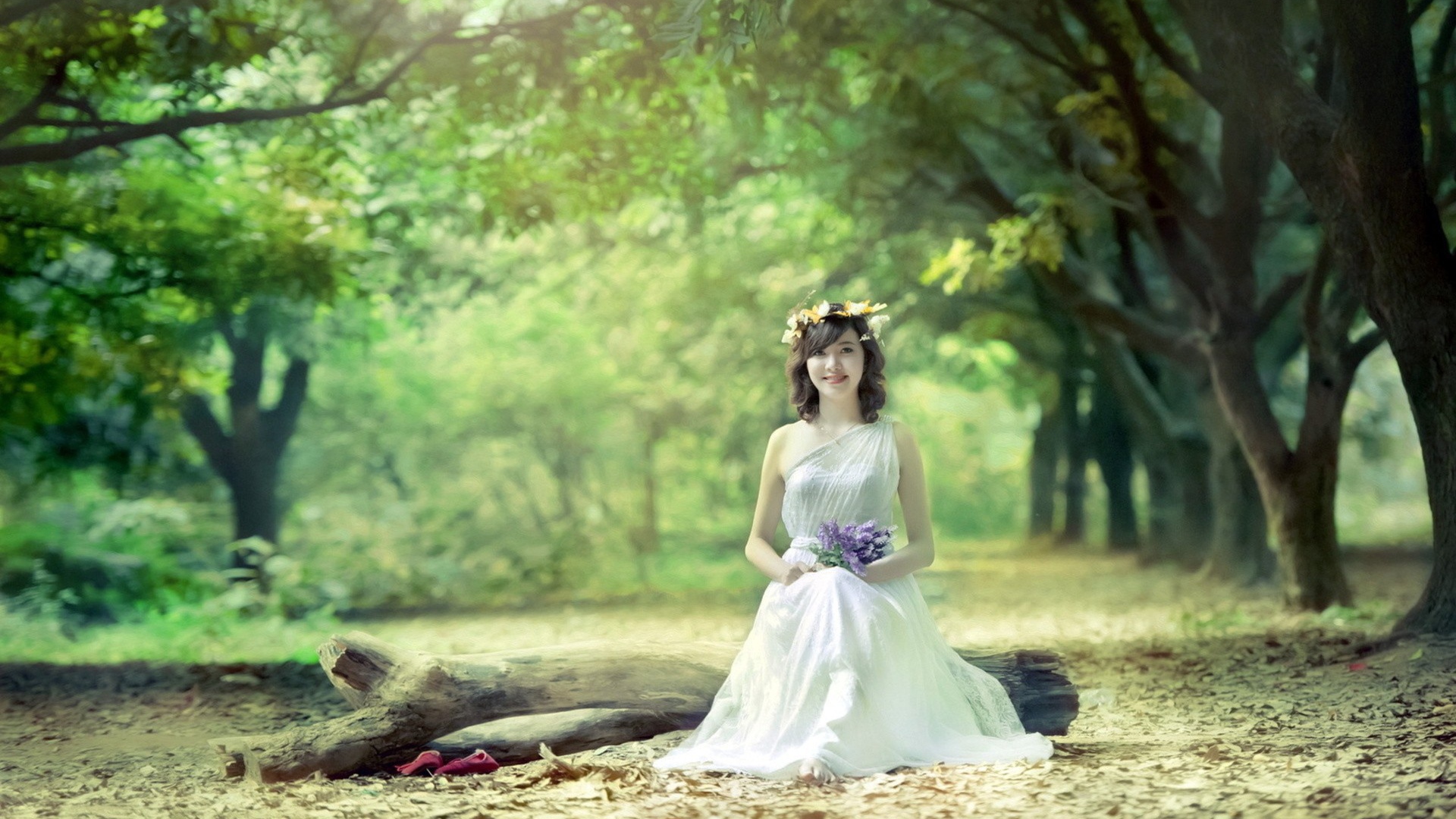 Девушка сидит на бревне