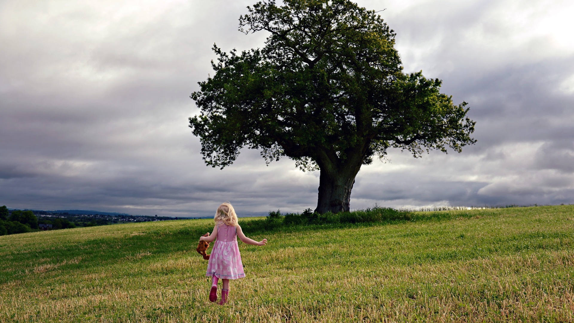 Маленькая девочка бежит к дереву