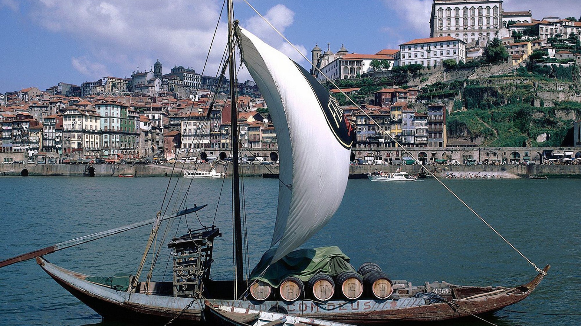 Парусная лодка на фоне города