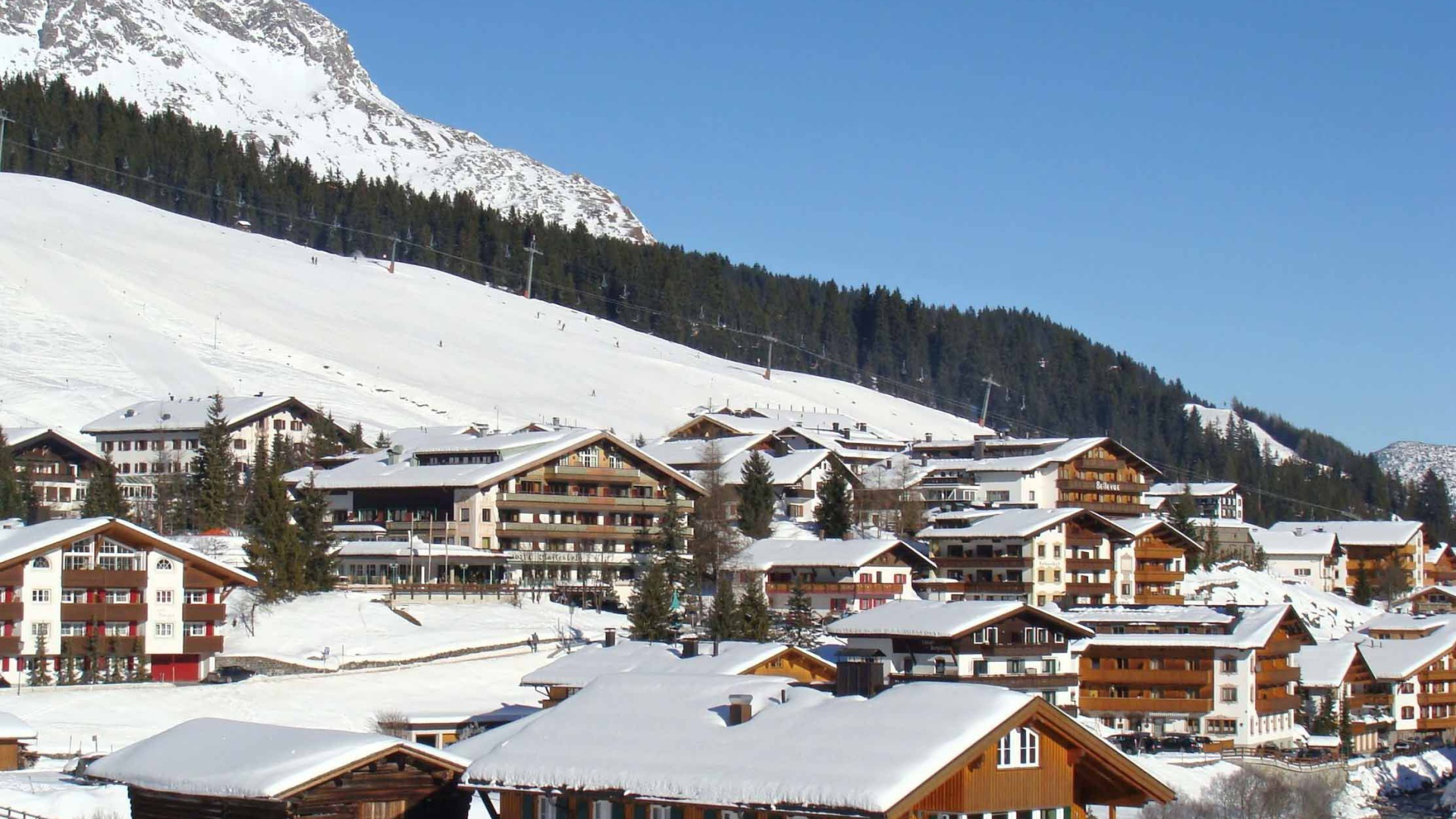 Дома на фоне гор на горнолыжном курорте Лех, Австрия