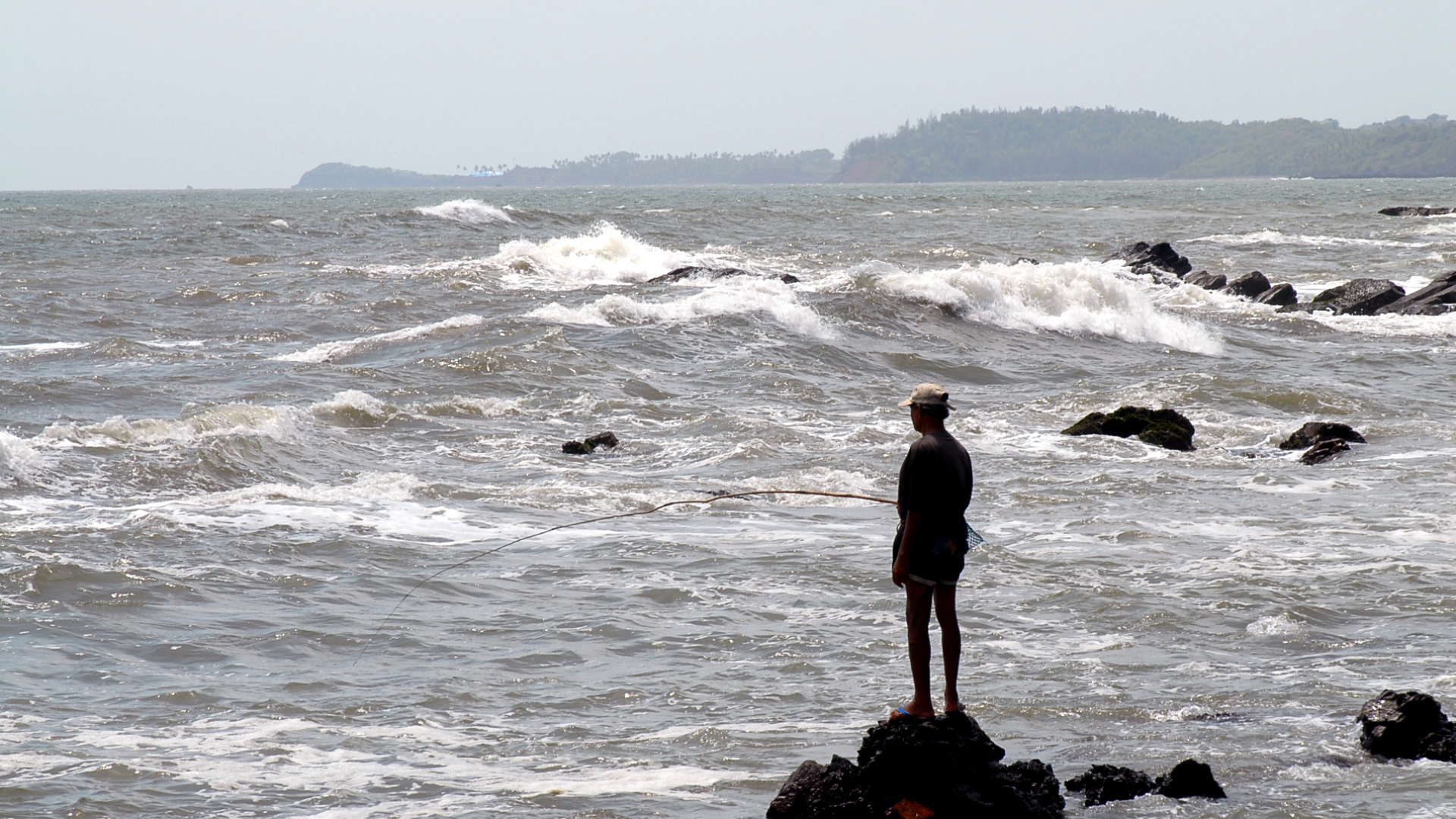 Мужчина ловит рыбу в Гоа