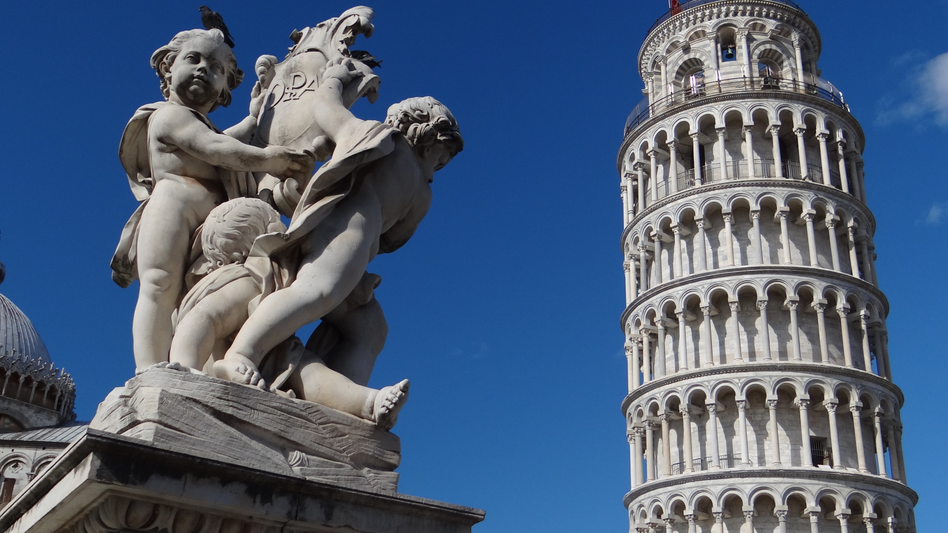 Статуя на фоне башни в Пизе, Италия