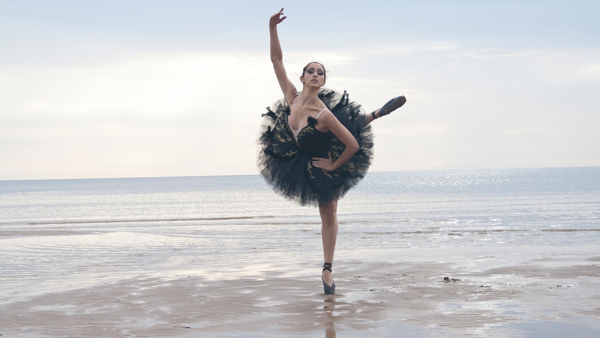 Балерина в черном на пляже