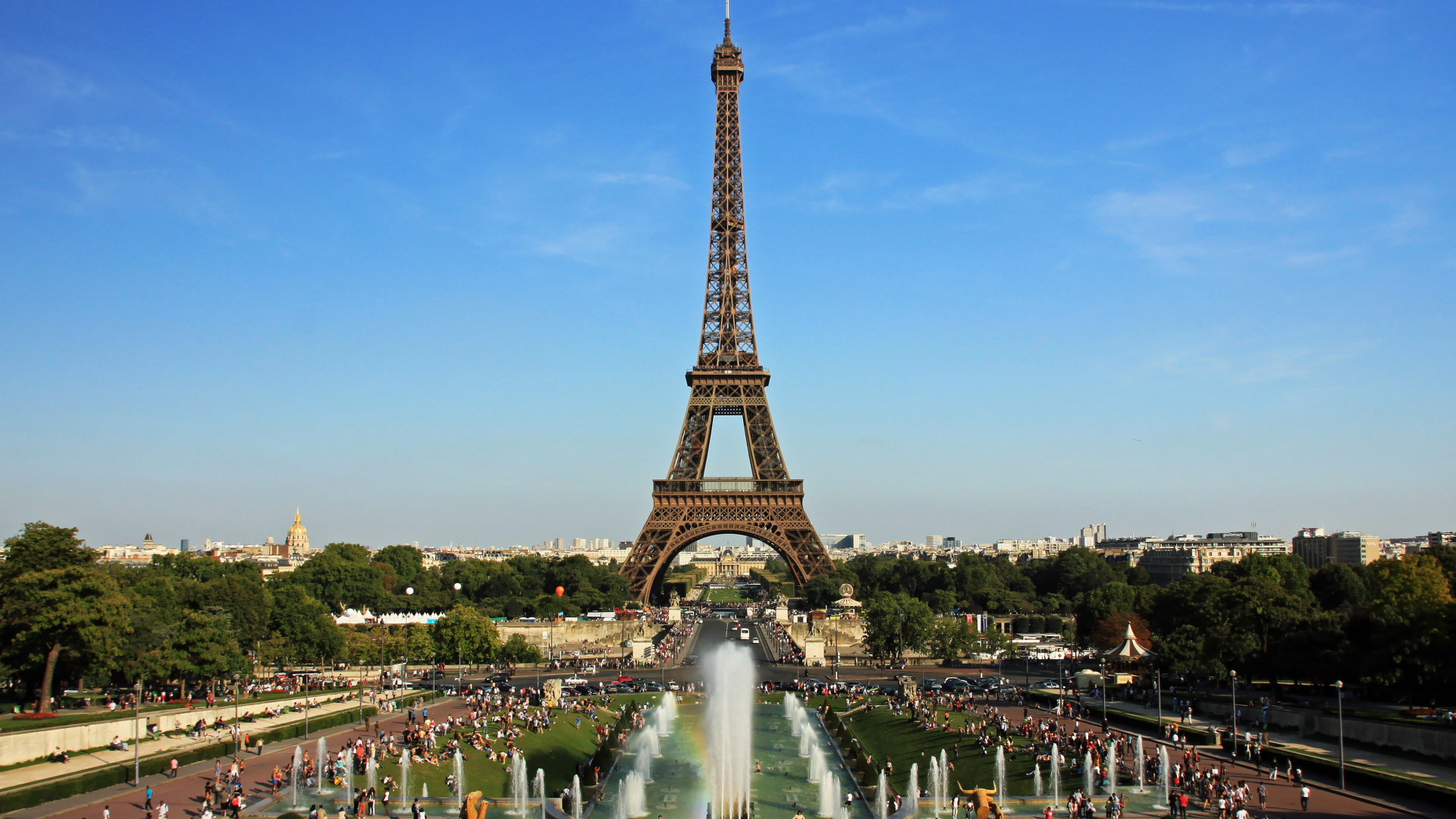 People rest near the Eiffel Tower and fountains