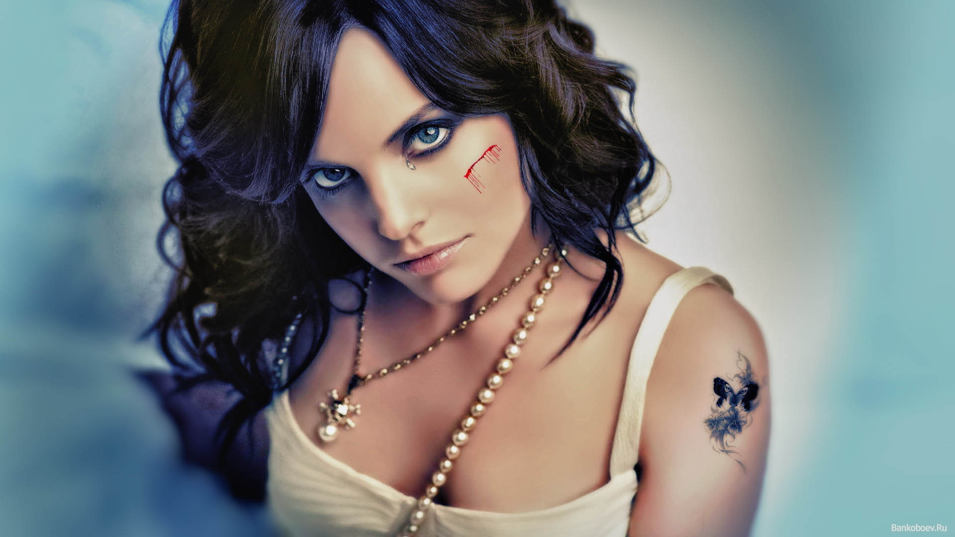 Шрам на щеке и татуировка на плече у девушки