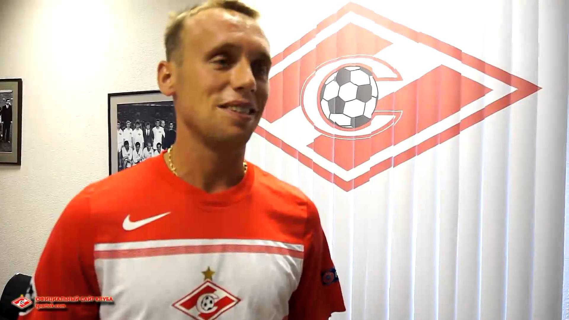 Денис Глушаков полузащитник Спартака на фоне логотипа команды