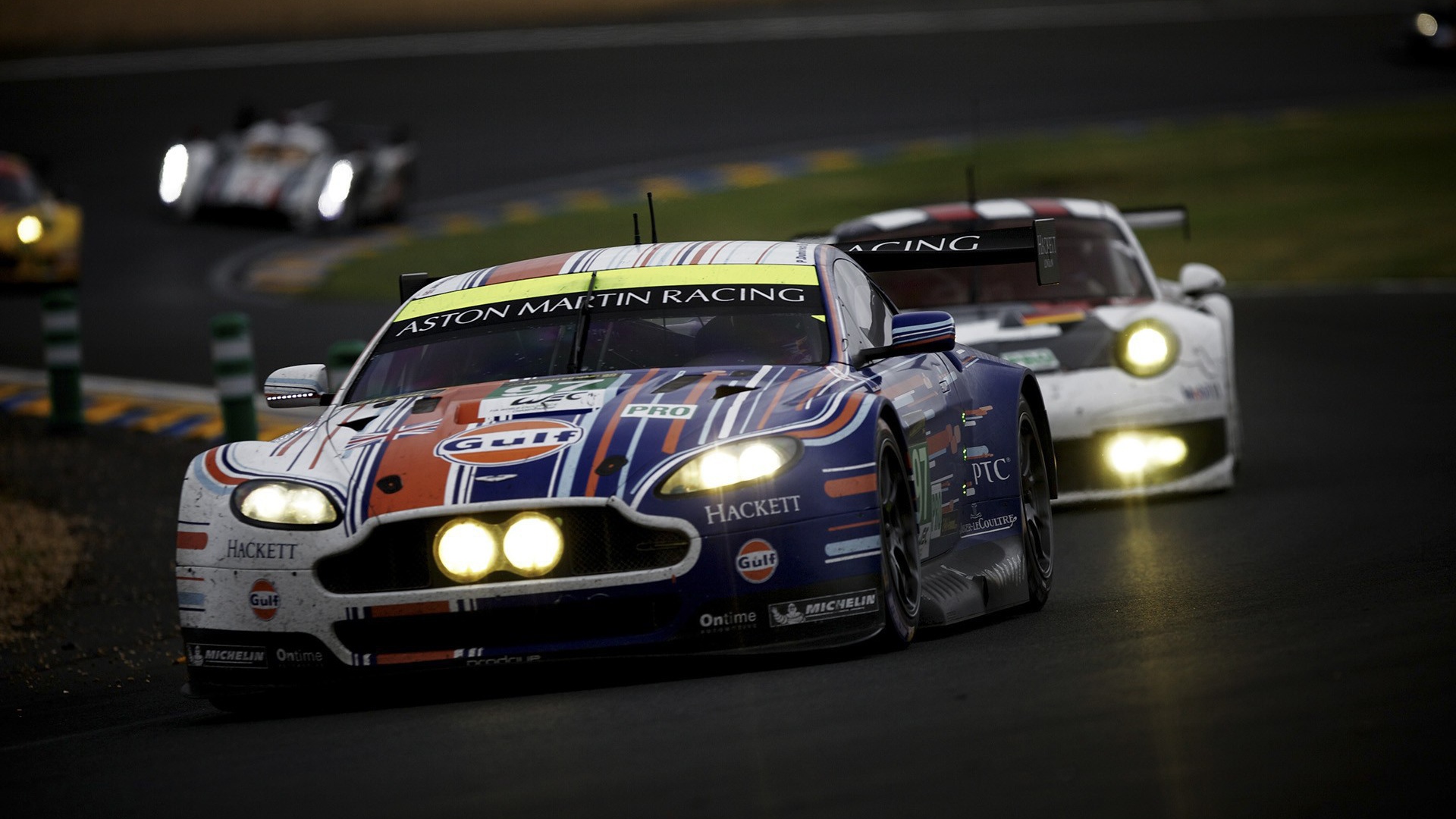 Гоночный Aston Martin с горящими фарами