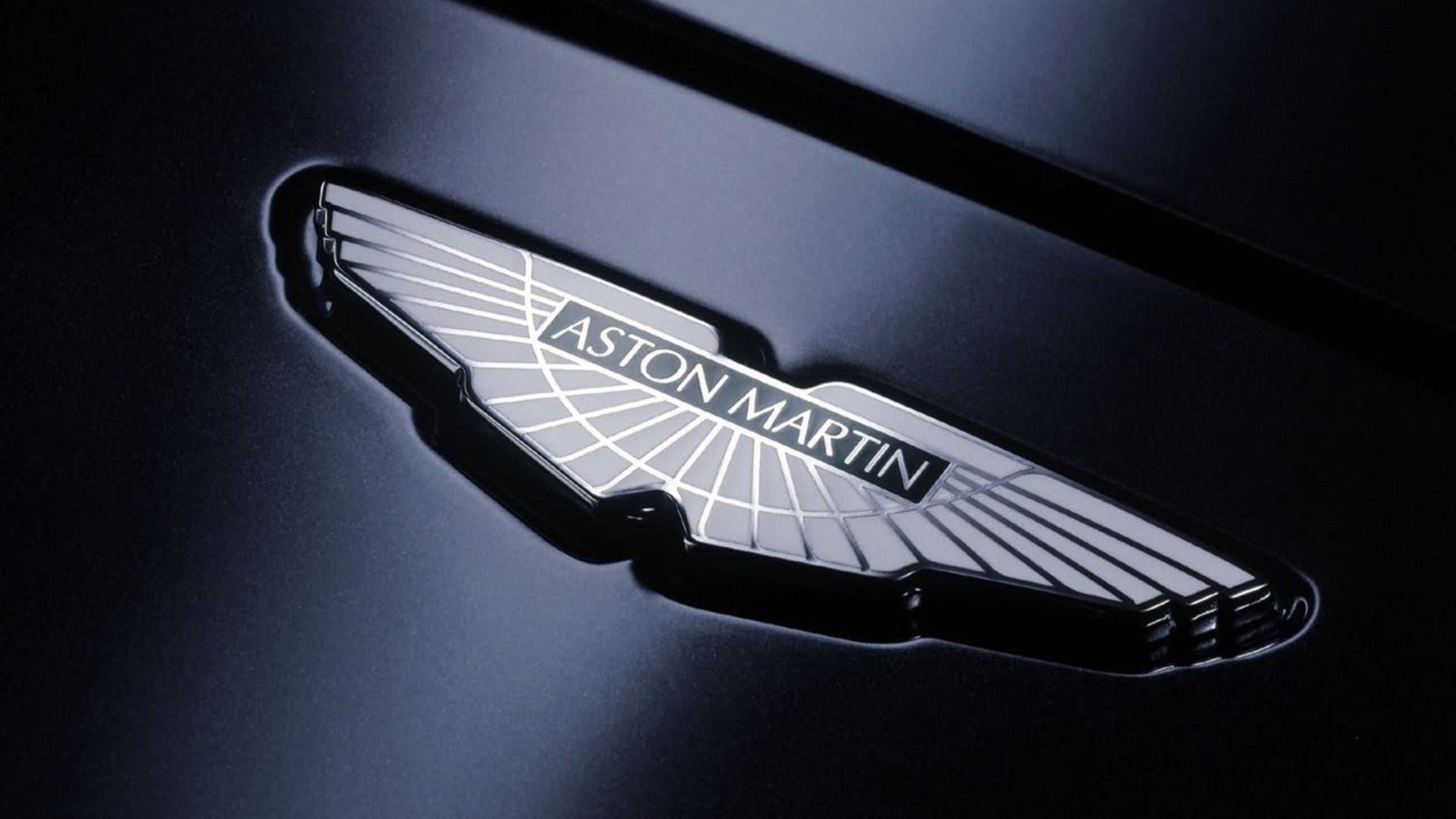 Логотип Aston Martin на черном фоне