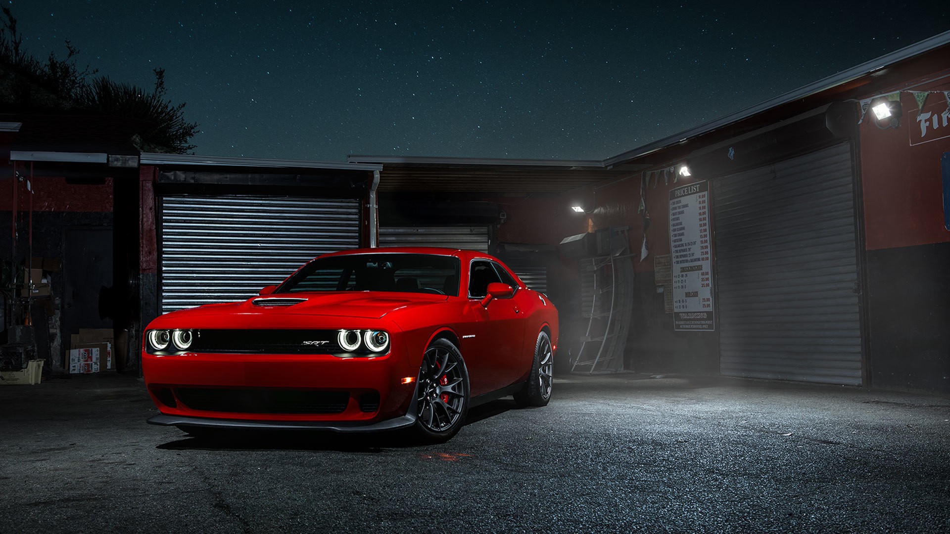 Красный Dodge Challenger Hellcat у гаража