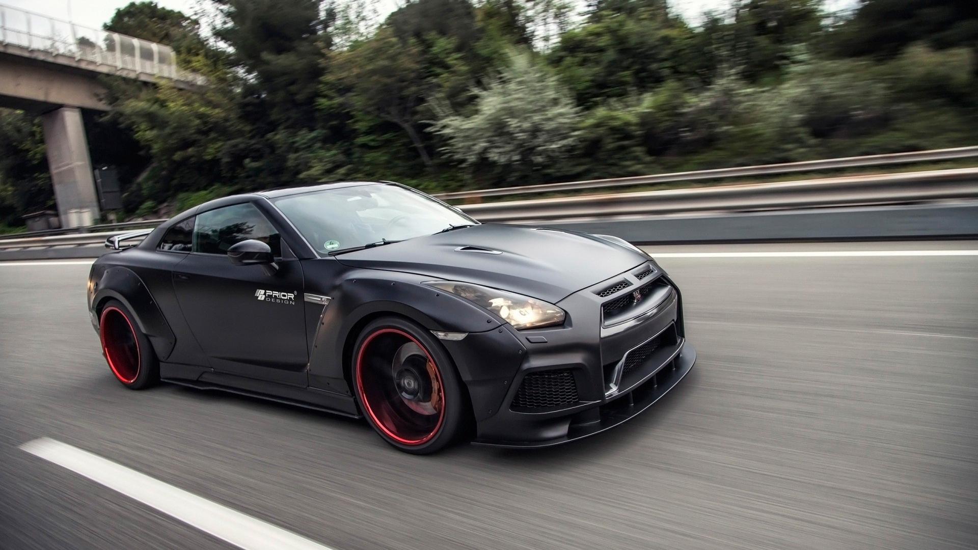 Черный Nissan GT-R PD750 Widebody мчится по шоссе