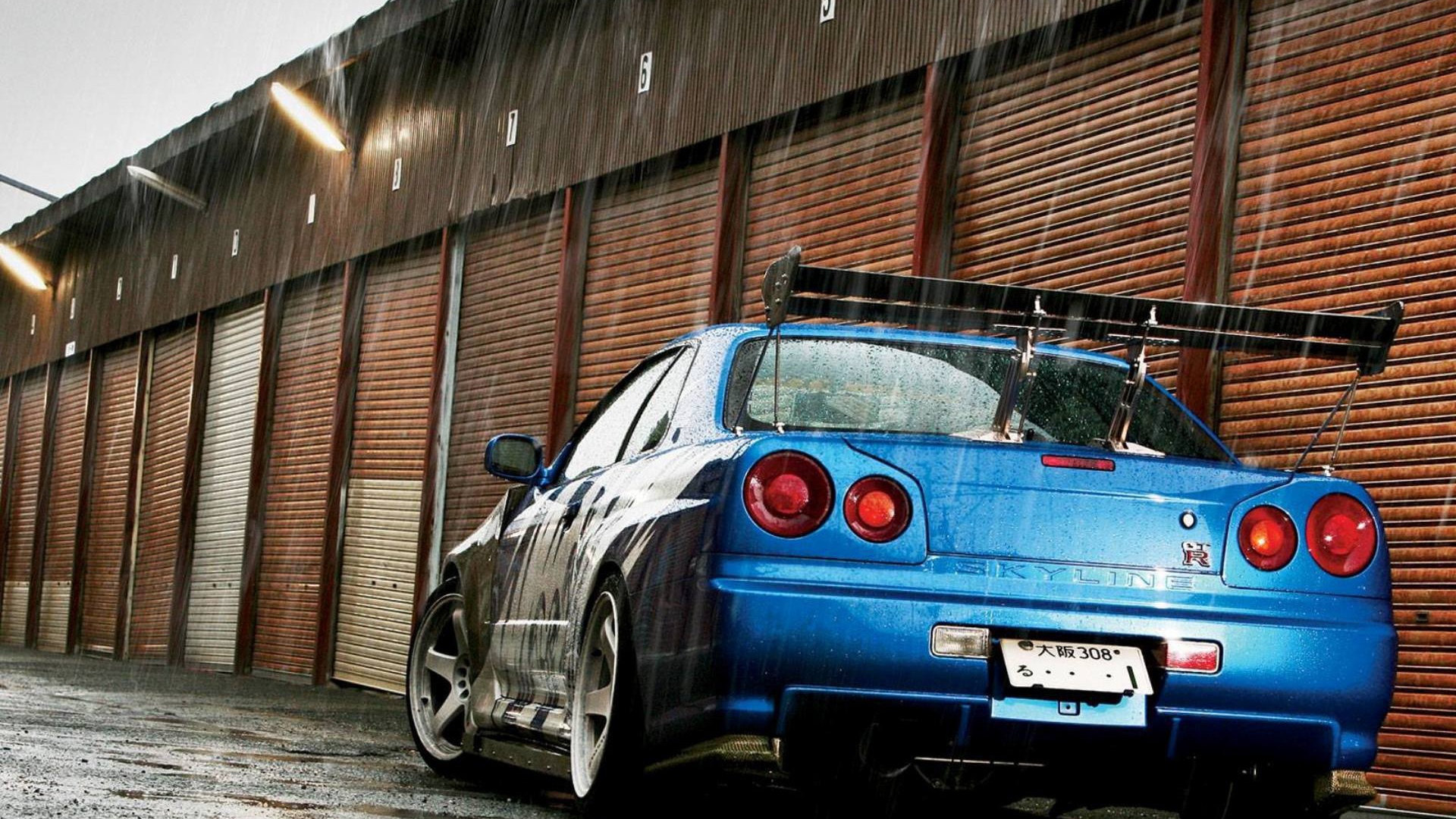 Синий Nissan Skyline GT-R R34 во время дождя