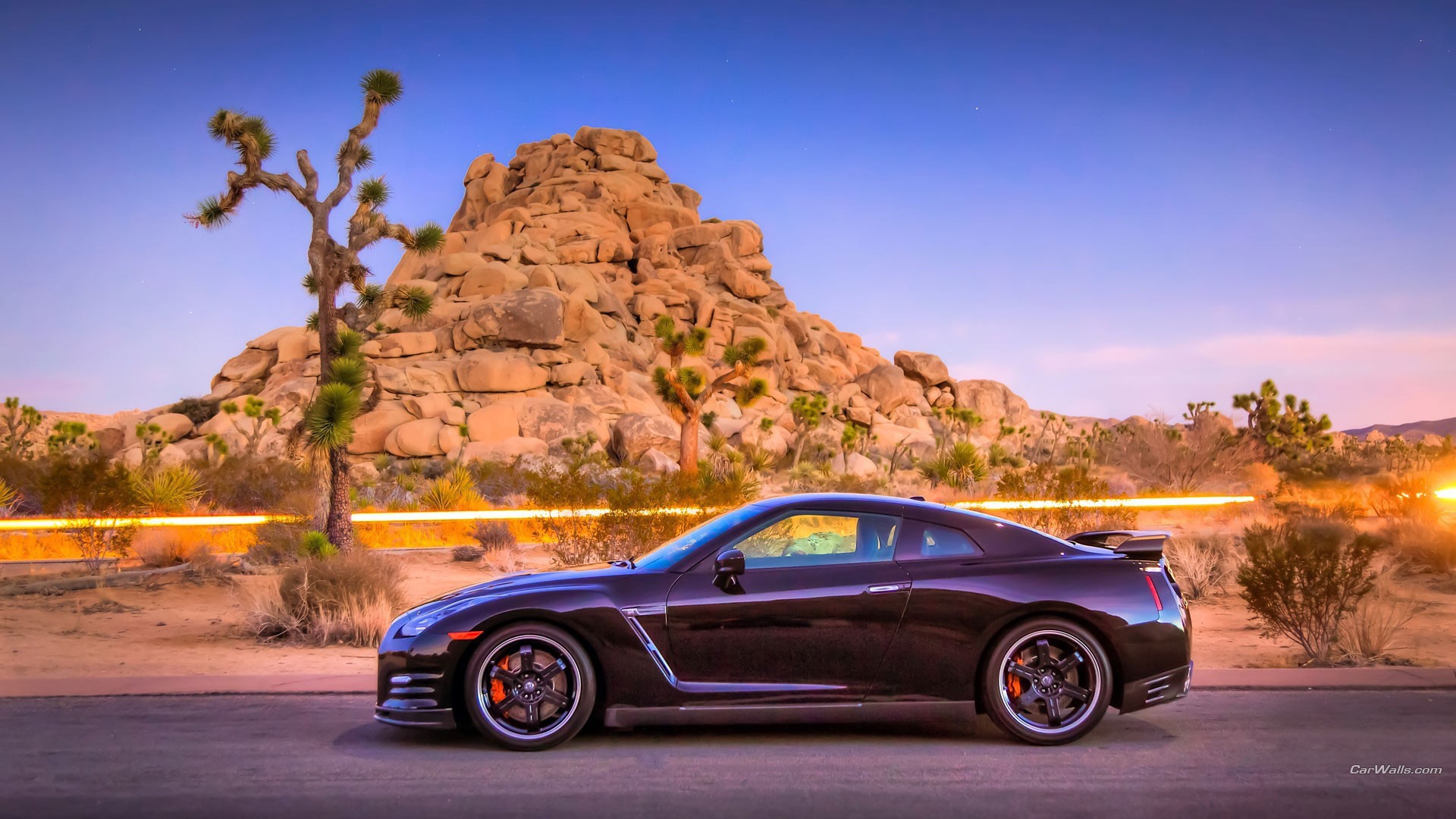 Автомобиль Nissan GT-R на фоне скалы