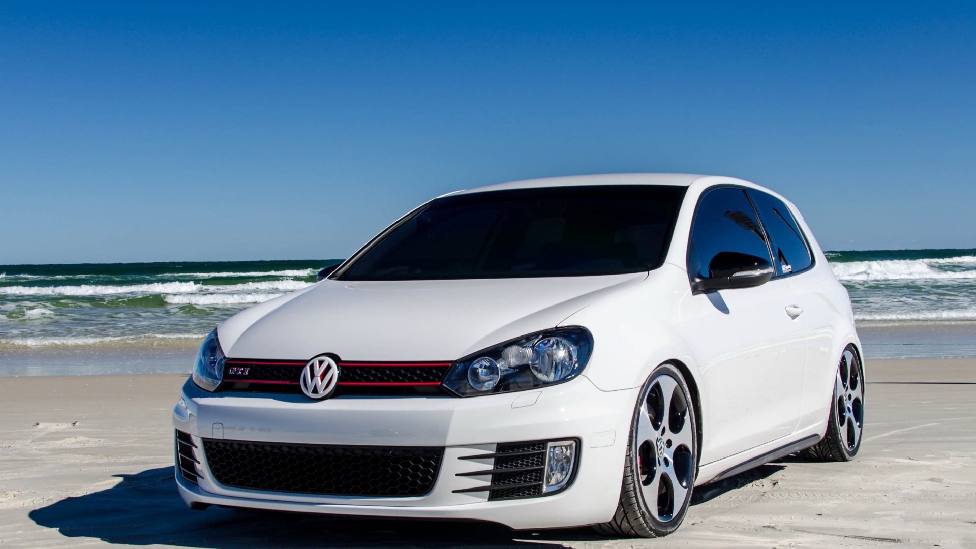 Белый Volkswagen Golf Mk6 GTI на берегу моря