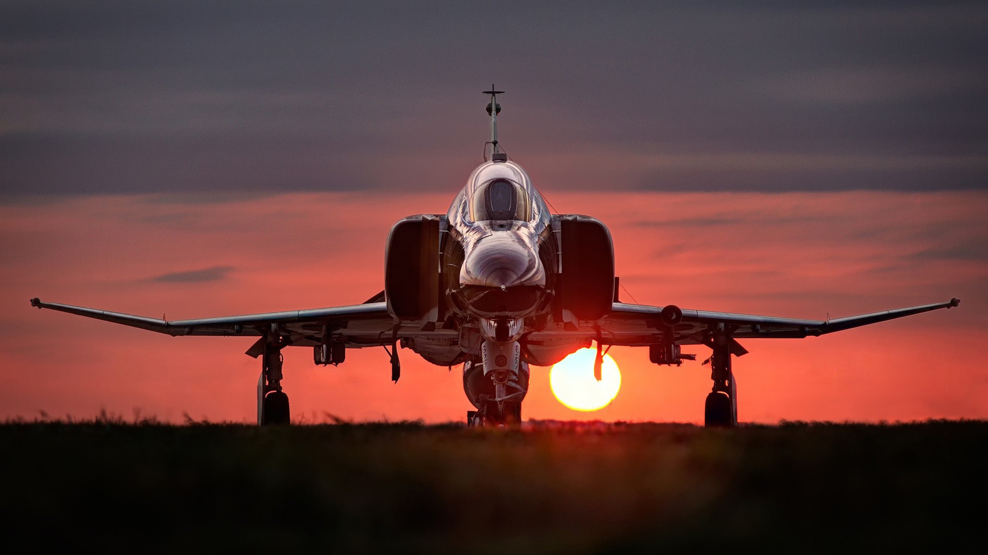 Истребитель F-4 Phantom II стоит на фоне заката