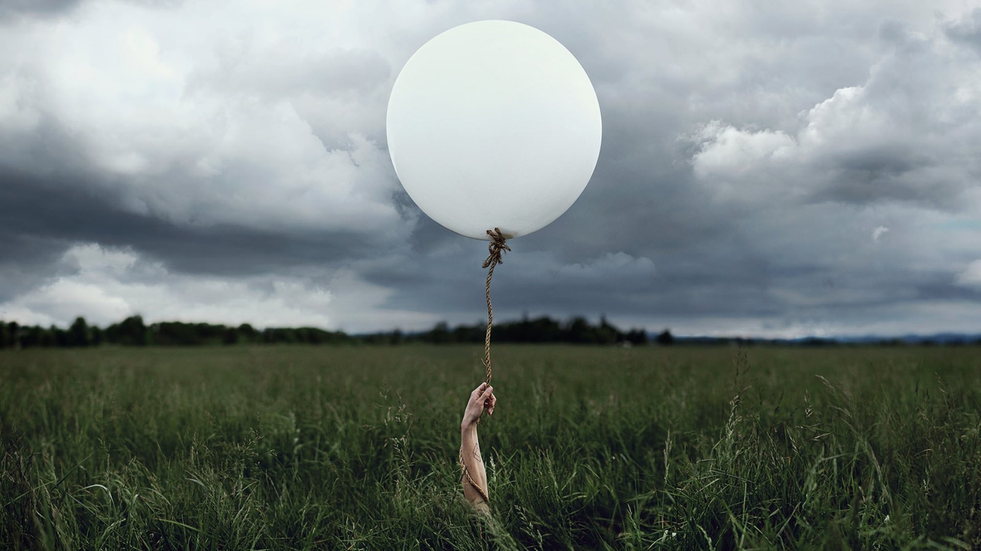 Рука с шаром среди поля