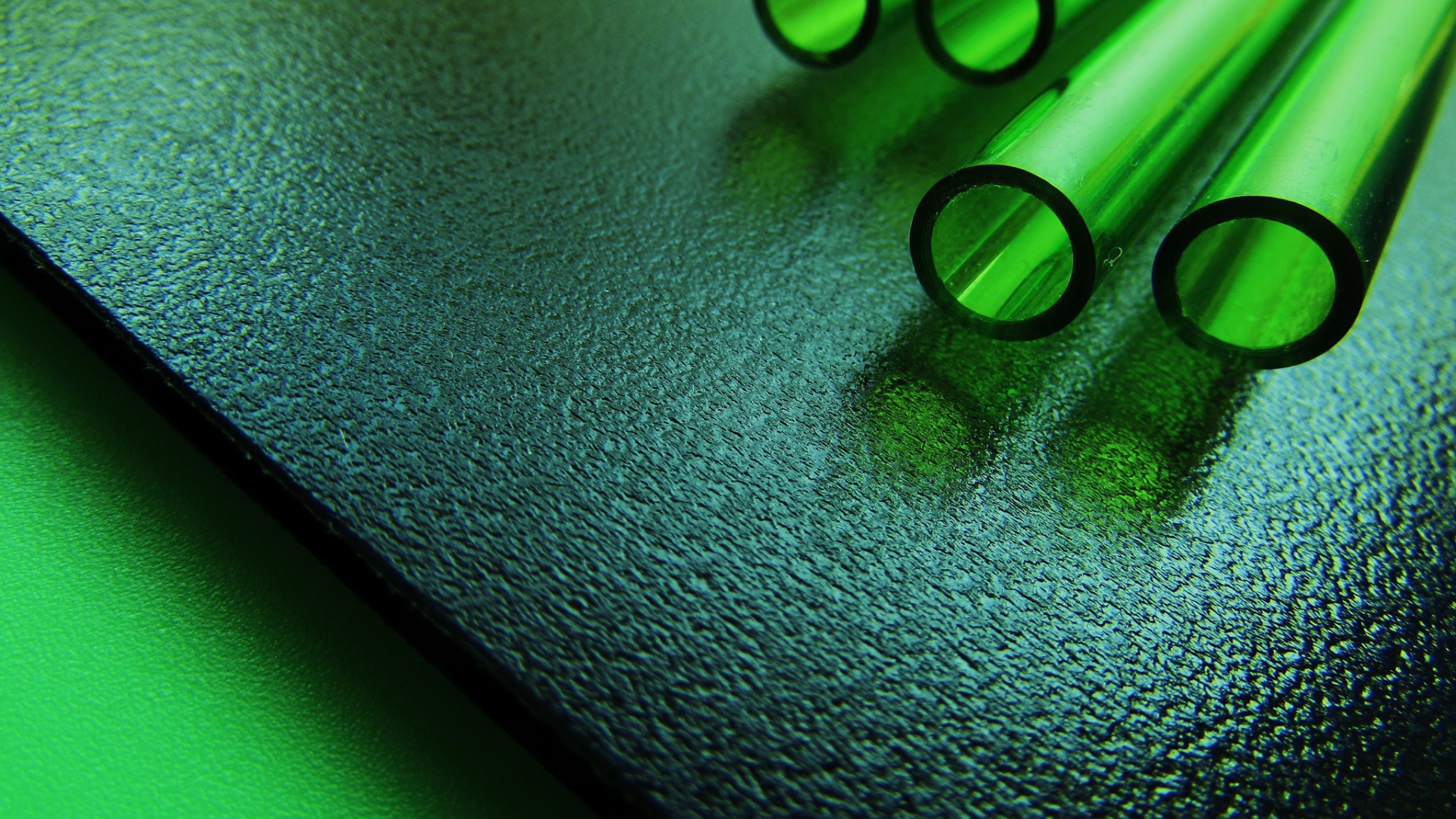 Трубки из зеленого стекла на черной плите