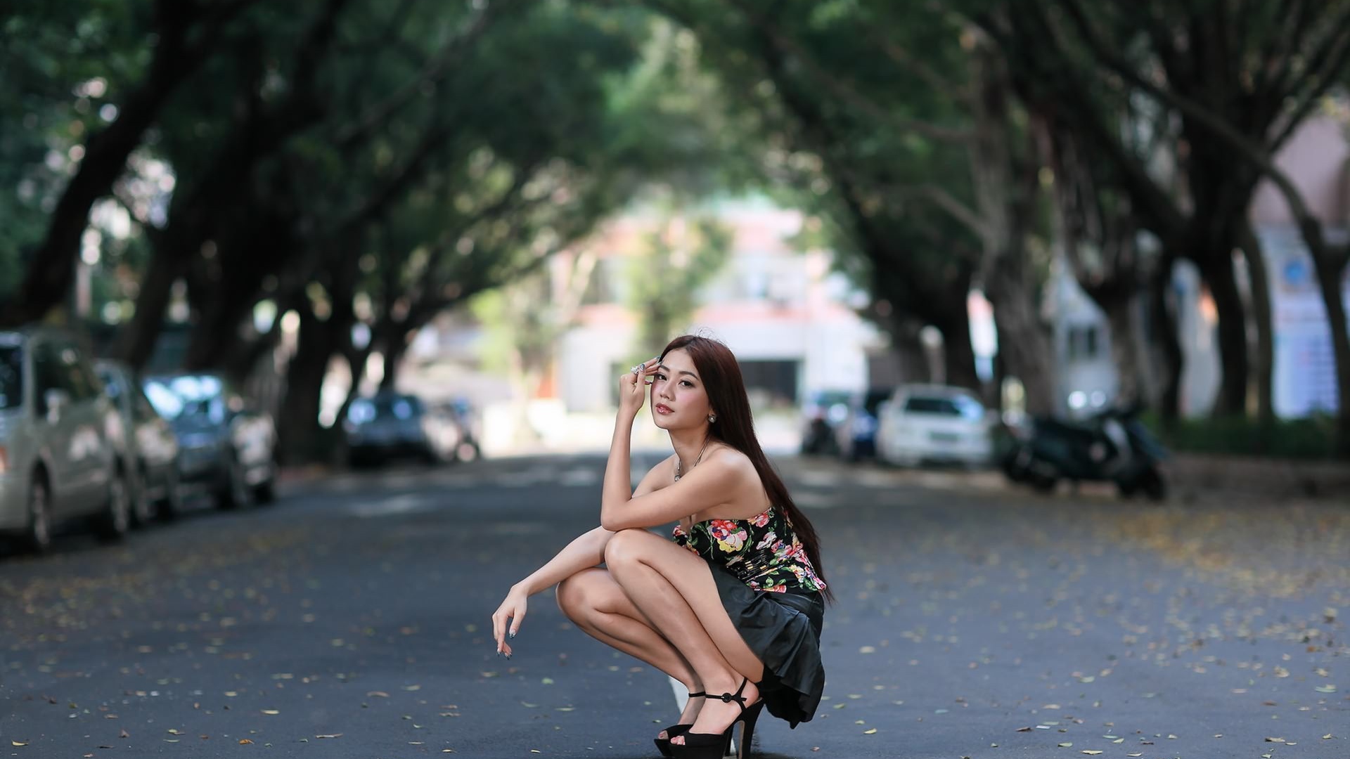 Азиатская девушка сидит на корточках