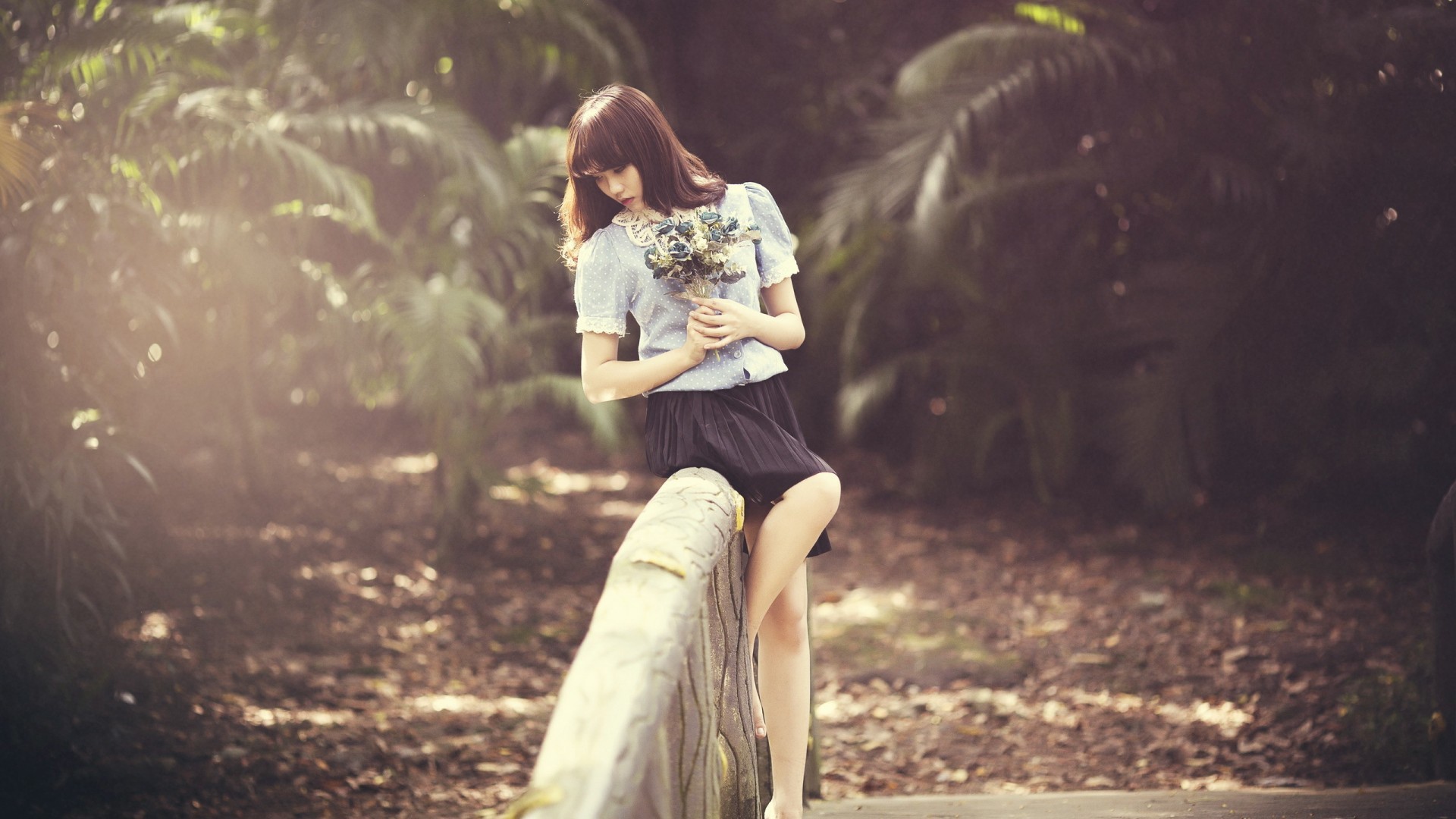 Азиатка с букетом на поручне моста