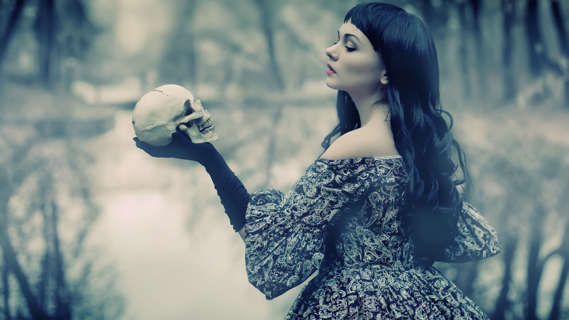 Брюнетка держит в руке череп