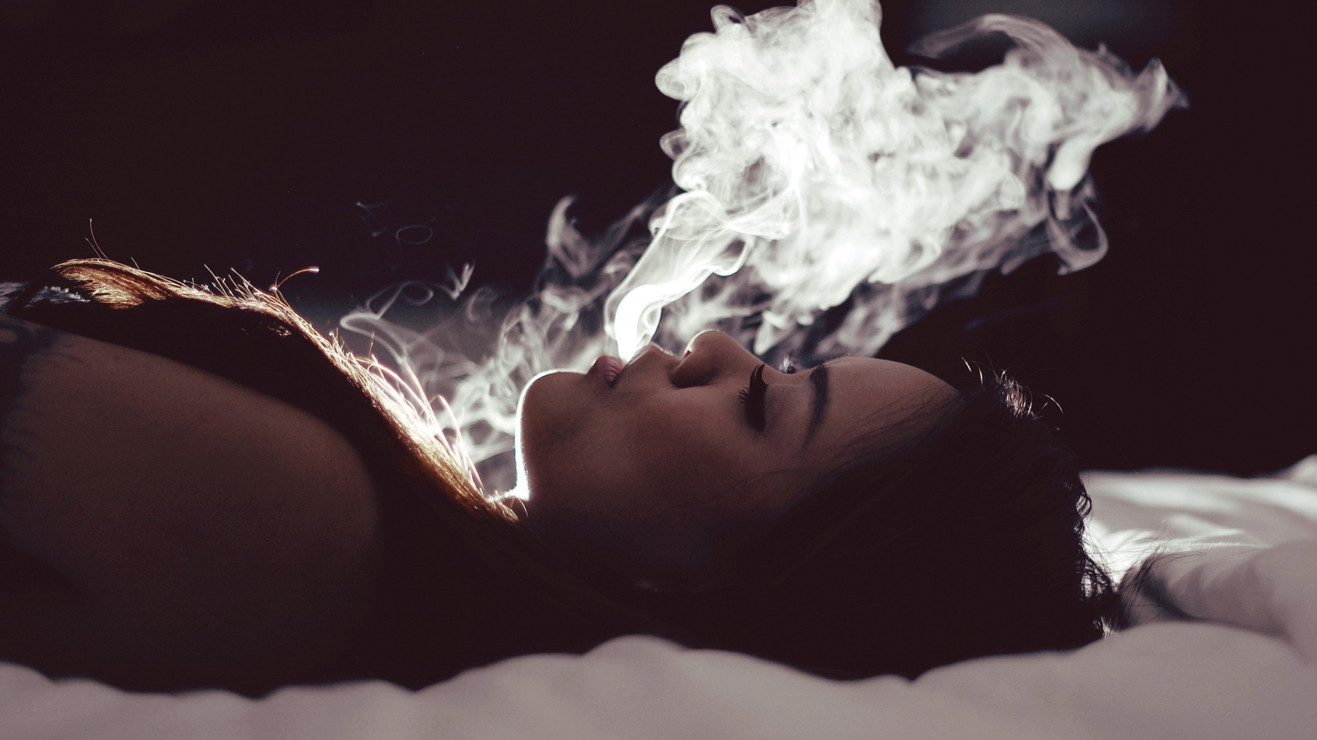 Девушка выпускает дым изо рта