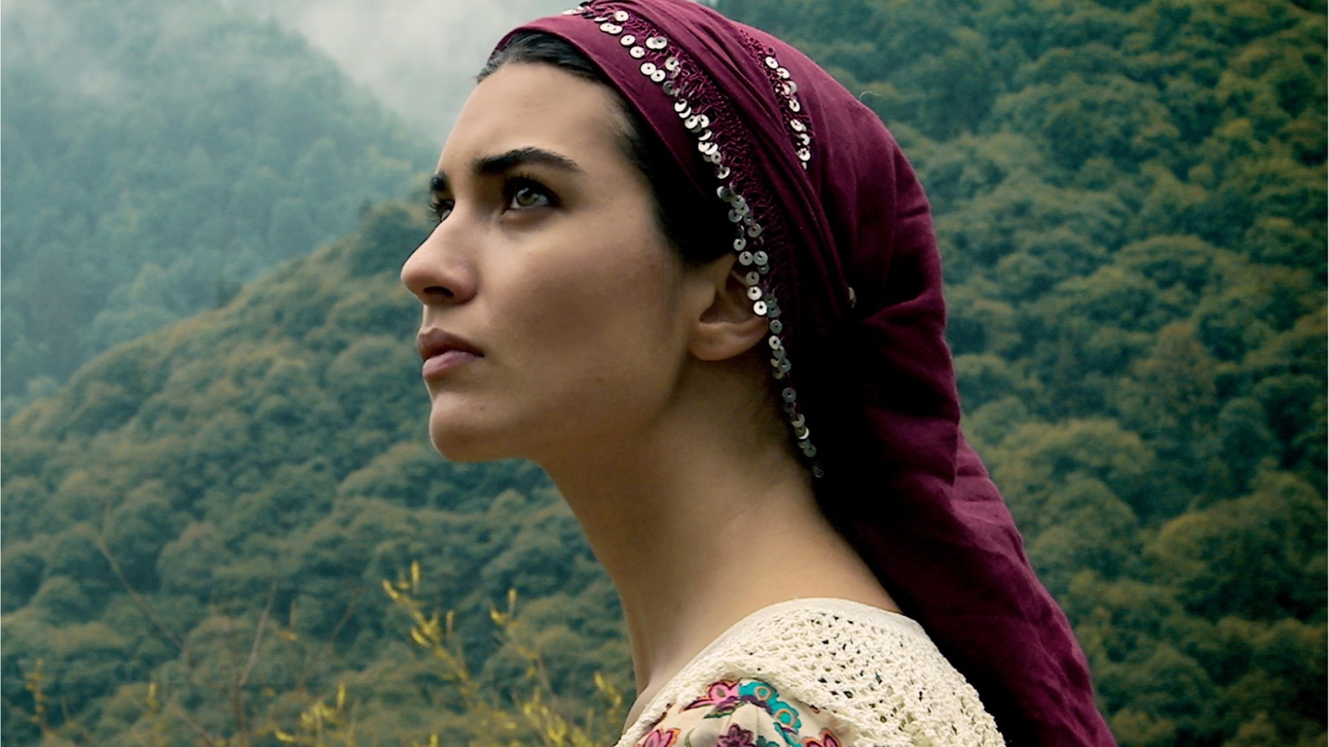 Девушка в красной косынке на фоне горного леса