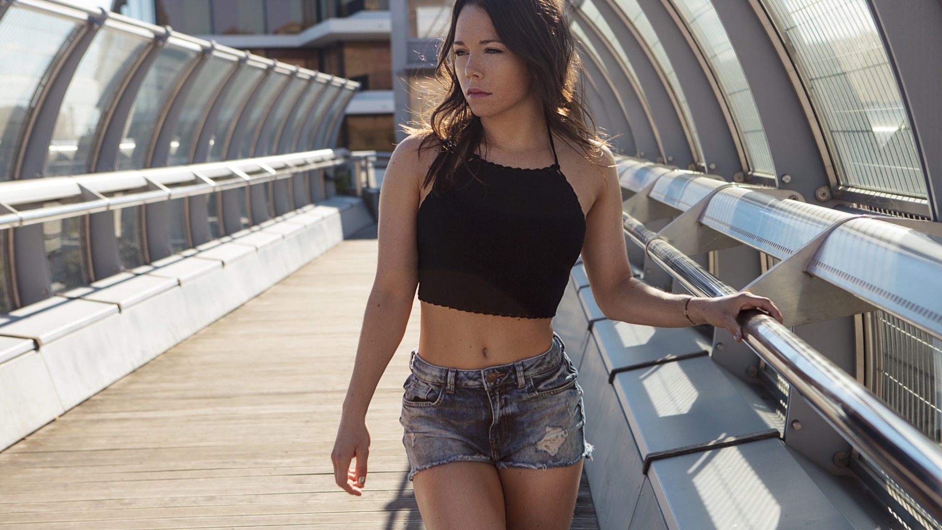 Девушка в джинсовых шортах на мосту