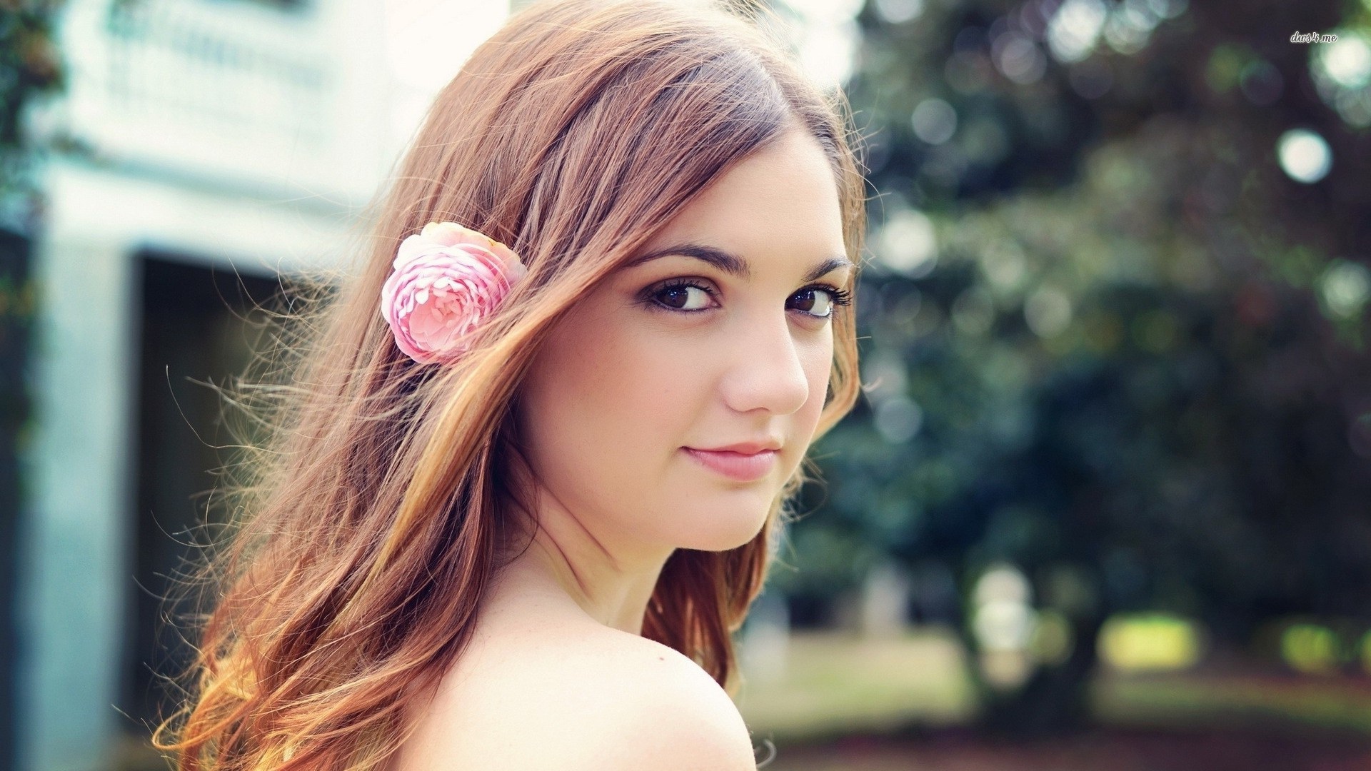 Девушка модель с розовым цветком в волосах