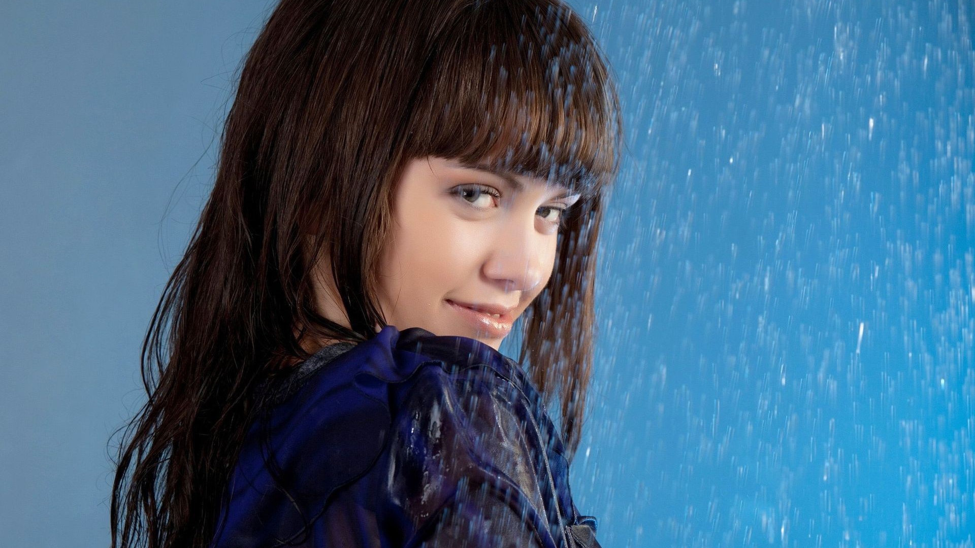 Девушка стоит под струей воды