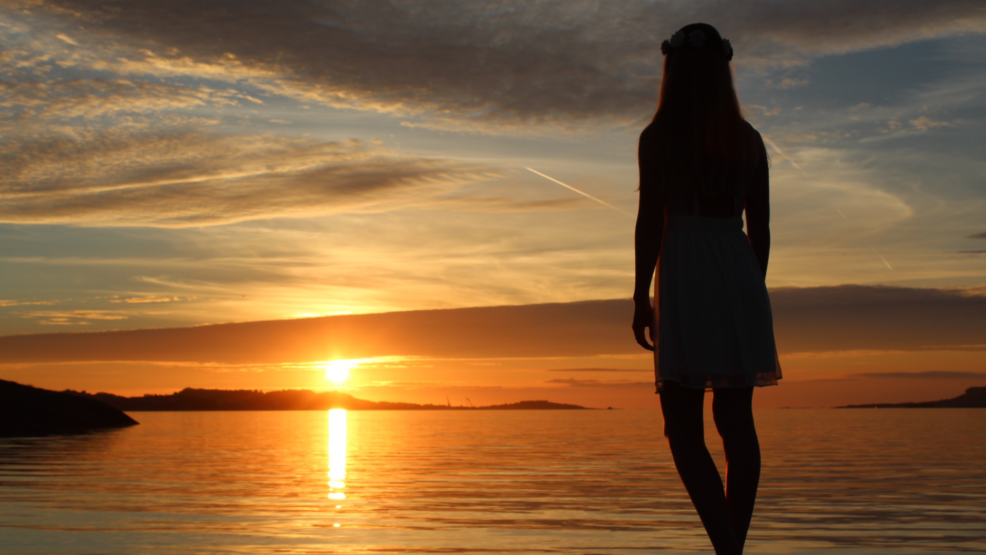 Девушка смотрит на закат в Норвегии