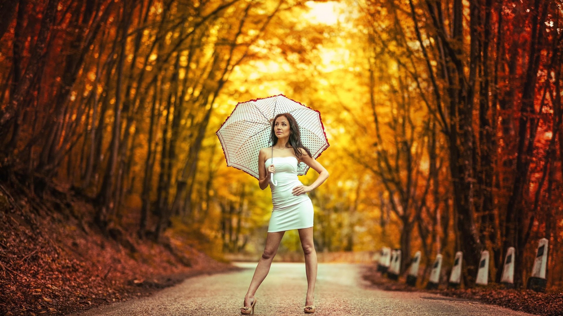 Девушка с белым зонтом стоит в осеннем парке
