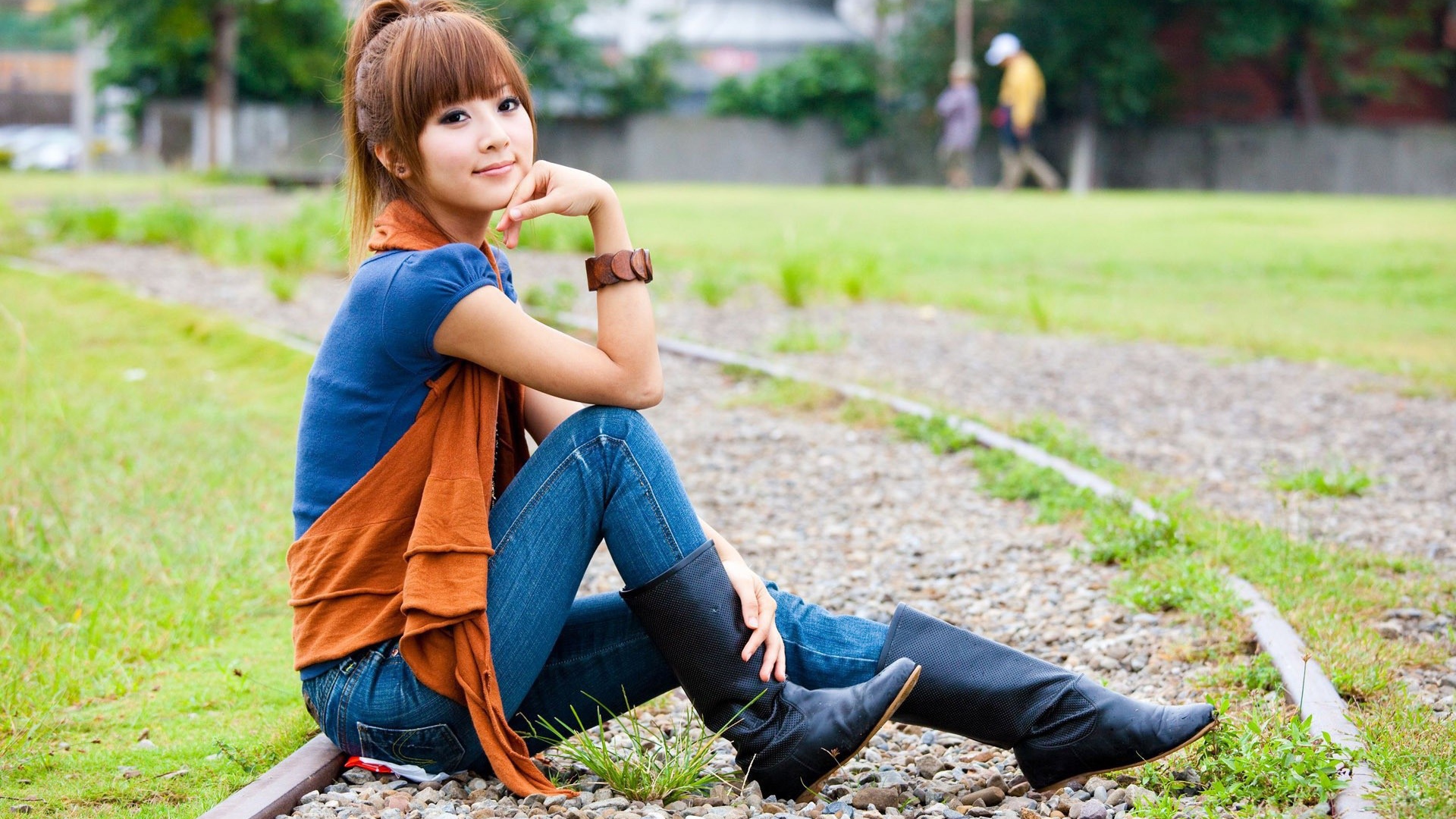 Японская девушка сидит на трамвайном пути