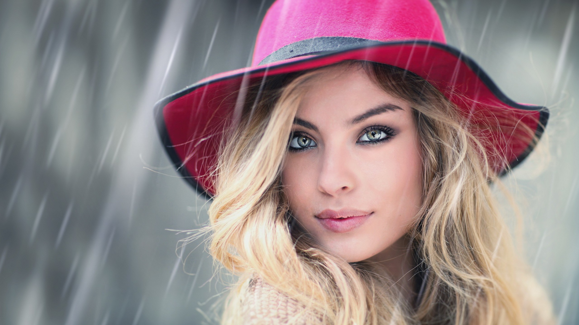 Блондинка в розовой шляпе под дождем