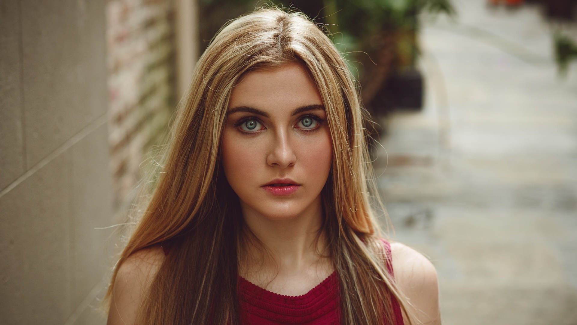 Блондинка с зелеными глазами идет по улице