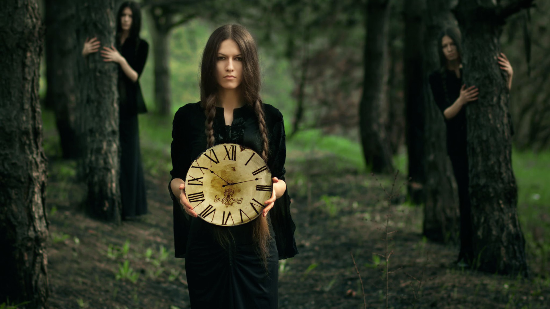 Девушка в черном платье держит часы в руках