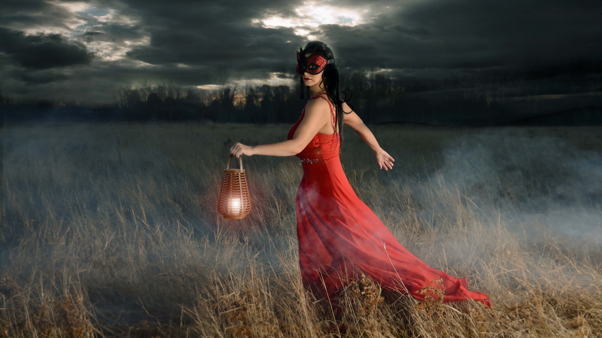 Девушка в красном платье с фонарем в поле