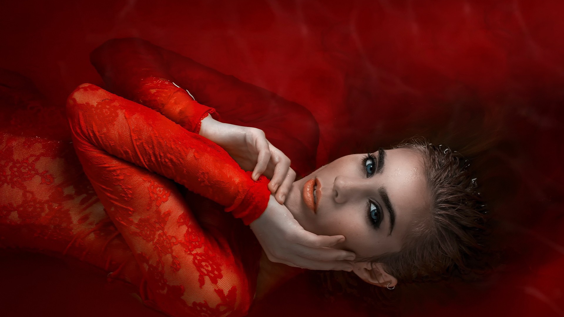 Девушка в красном кружевном платье на красном фоне