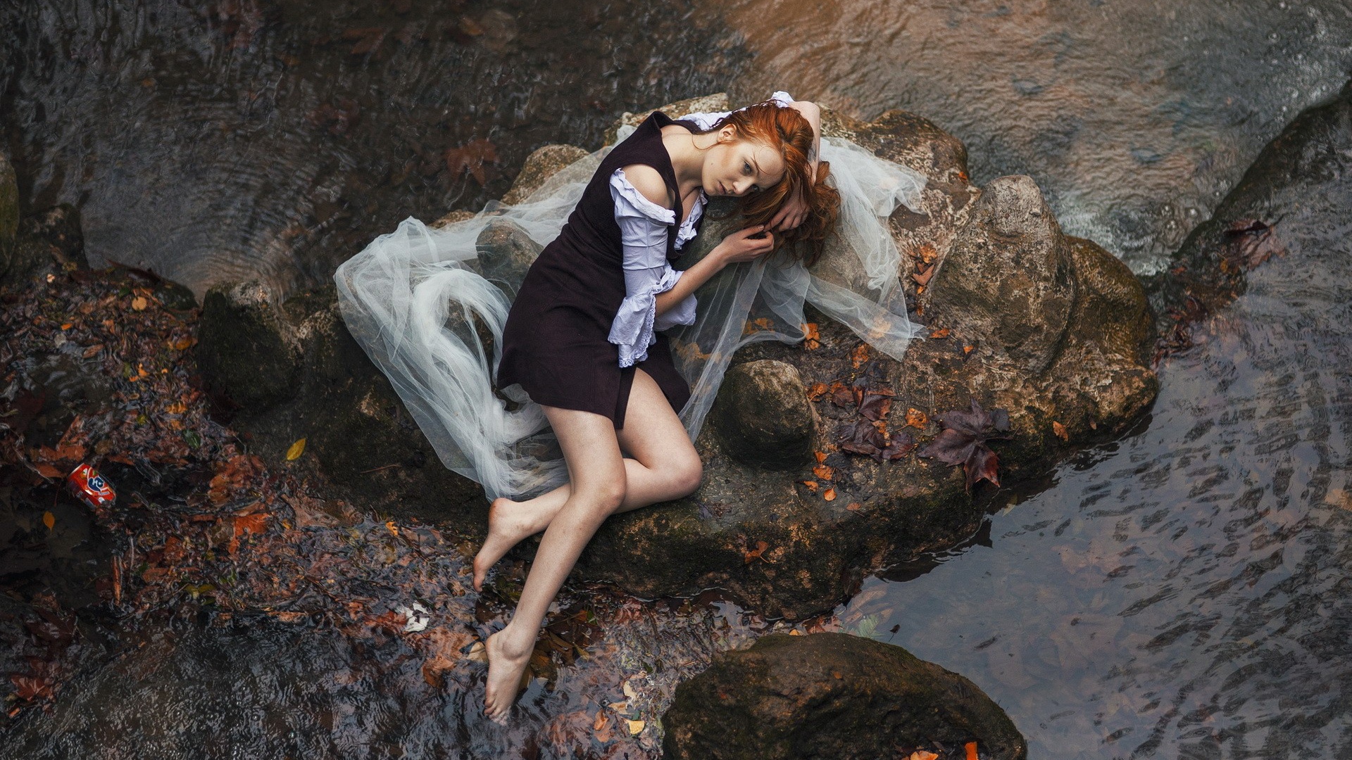 Девушка лежит на камне среди воды