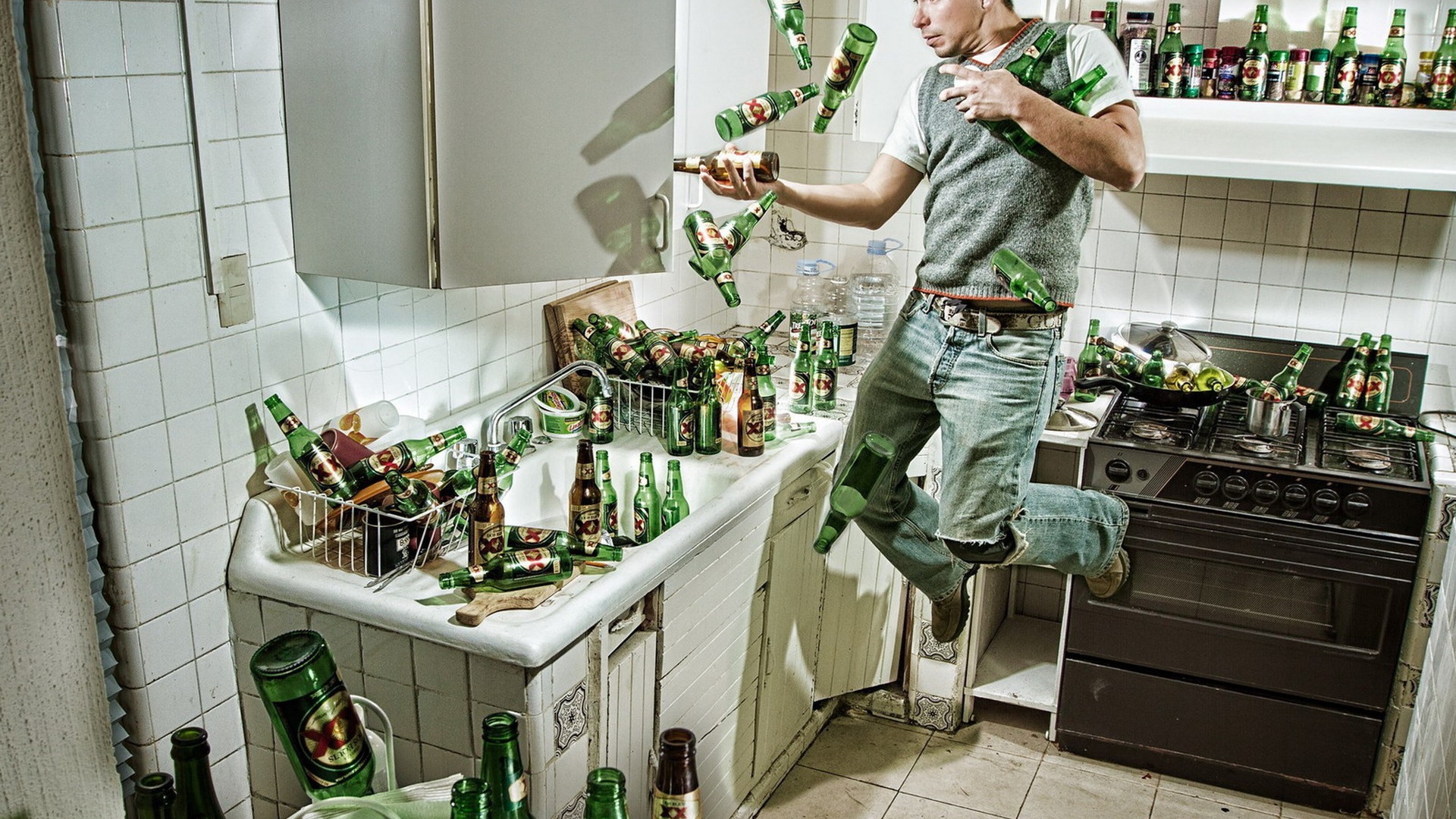 Мужчина среди бутылок пива на кухне