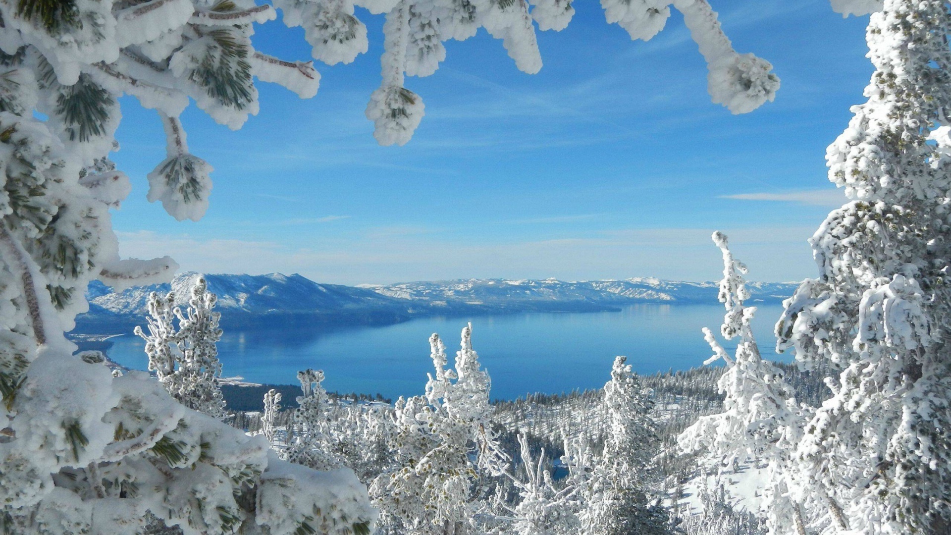 Горное озеро в рамке из заснеженных ветвей