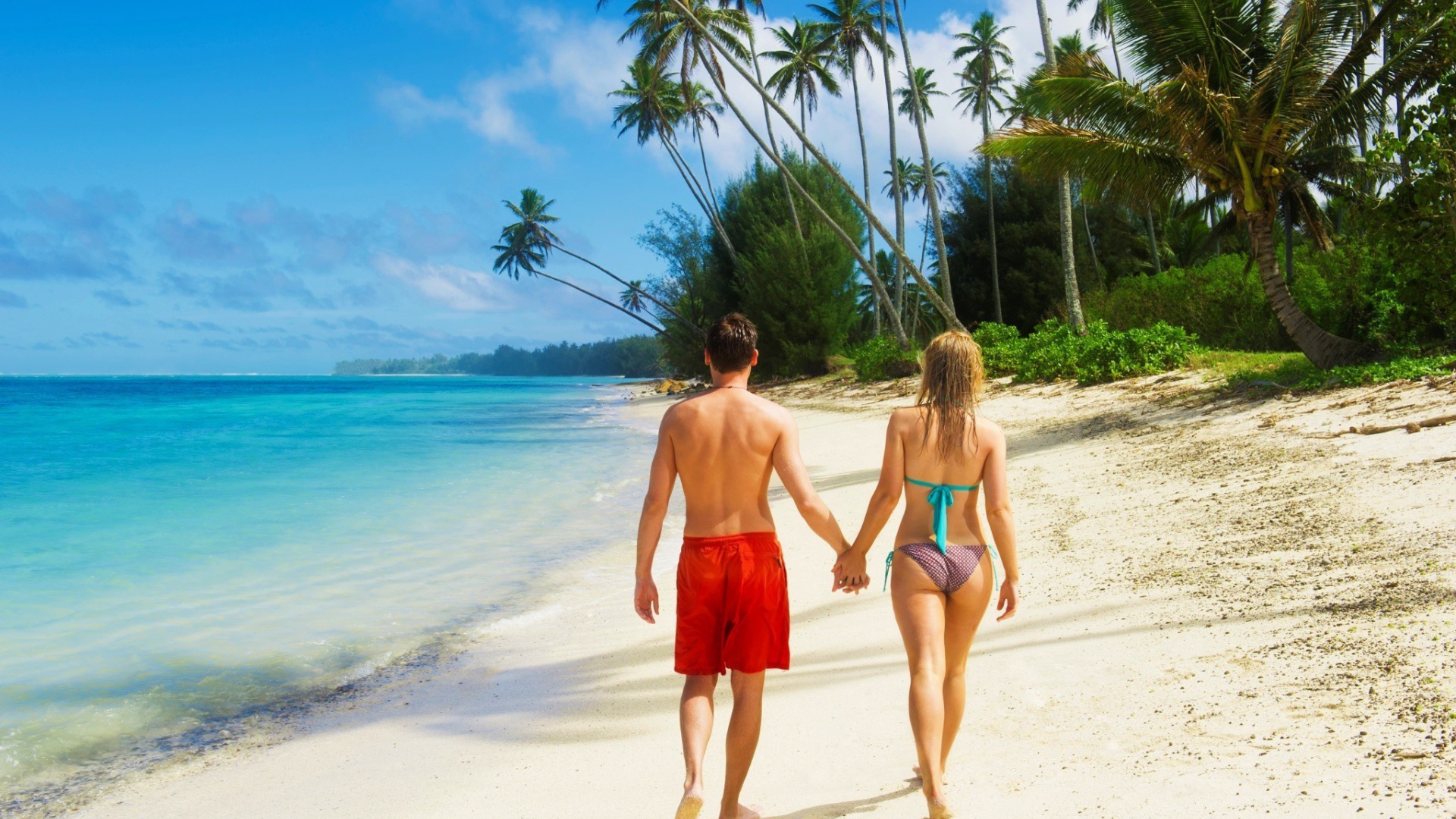 Парень и девушка идут по пляжу